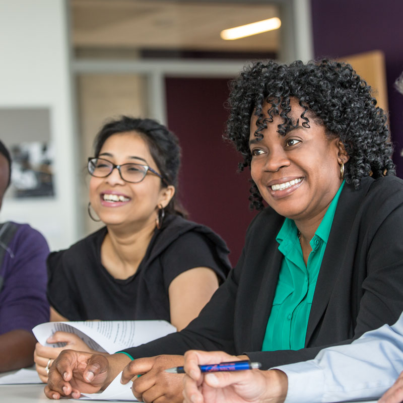 A close up of a smiling women of colour in a meeting