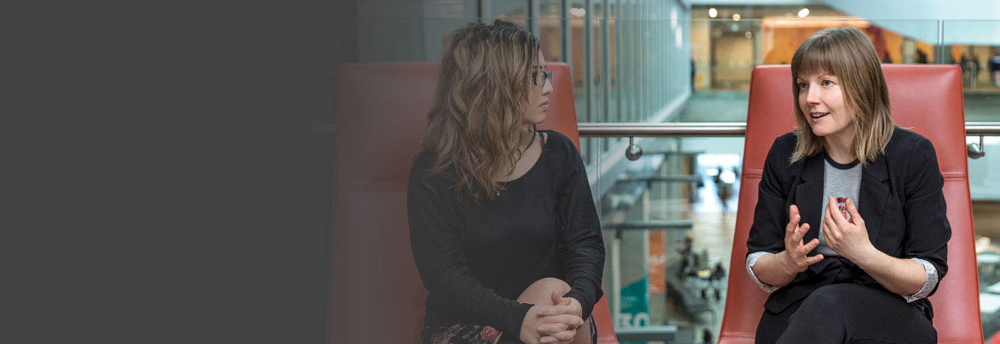 Two women sitting having a conversation in the Atrium