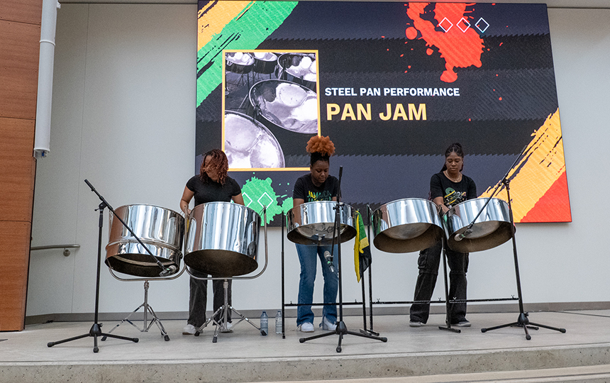 Three people playing steel pan drums