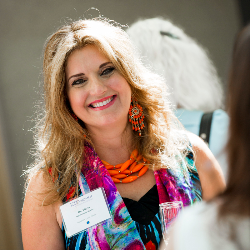 A smiling women at a 1000 Women fundraising event 