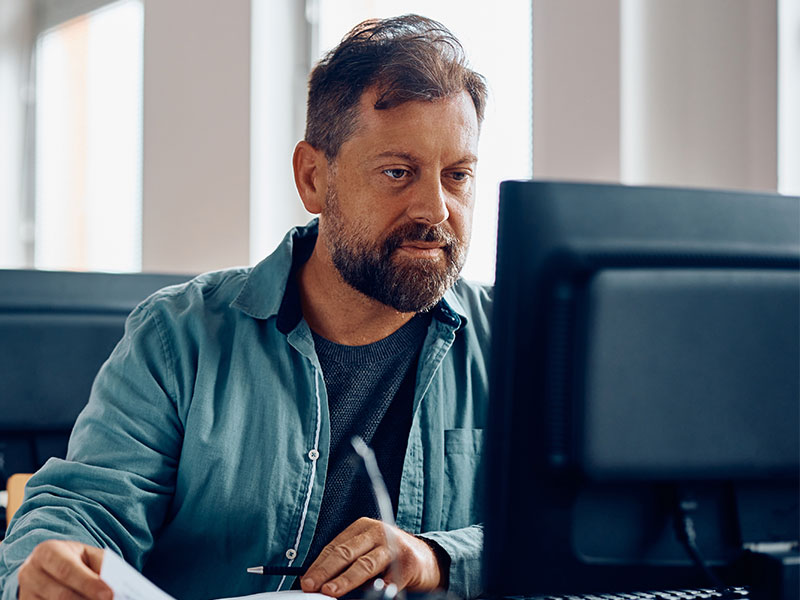 A middle aged man working on a computer