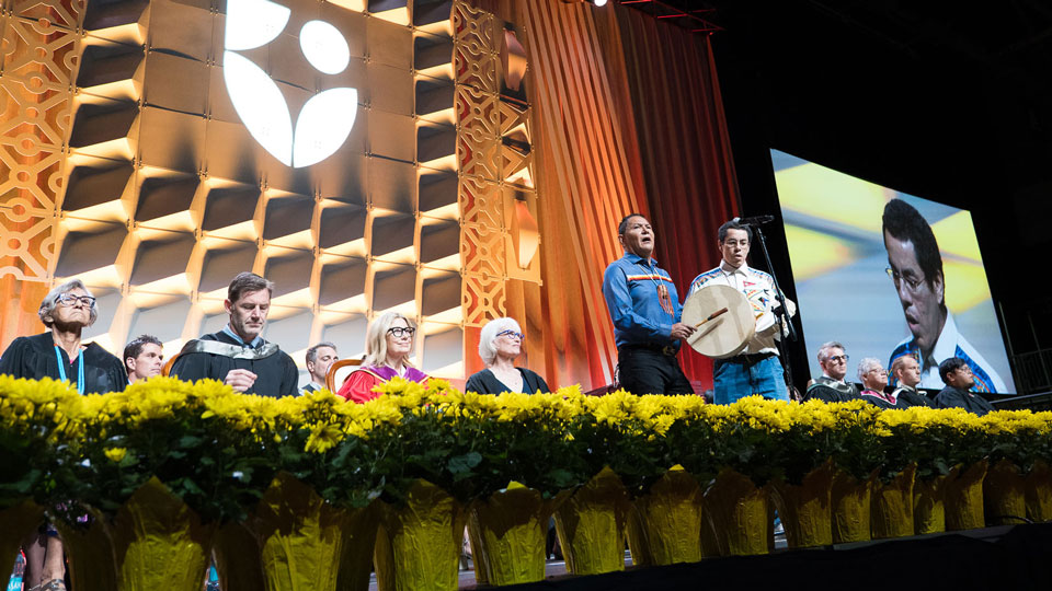 Two Indigenous men preforming on stage